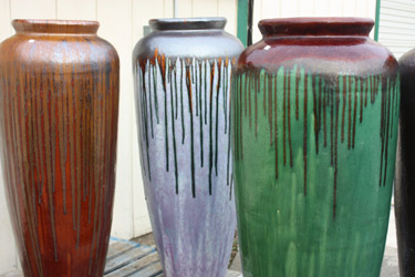 Tall brown, gray, and green vases, all part of the large pottery selection you can find at Bark & Garden Center.
